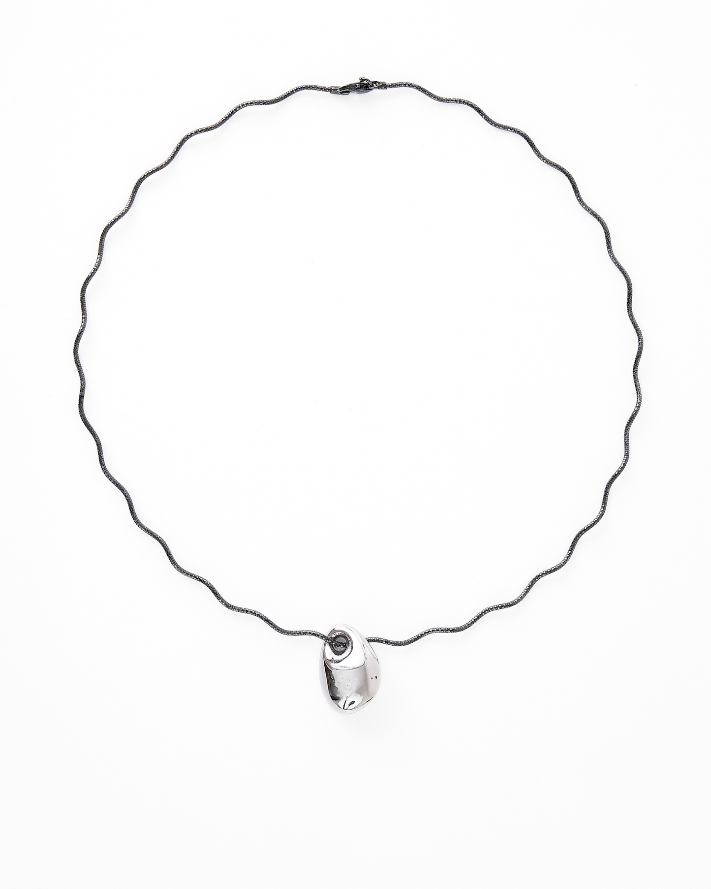 Contemporary necklace featuring a sculptural silver-tone pendant on a wavy black gold vermeil chain, styled against a white background