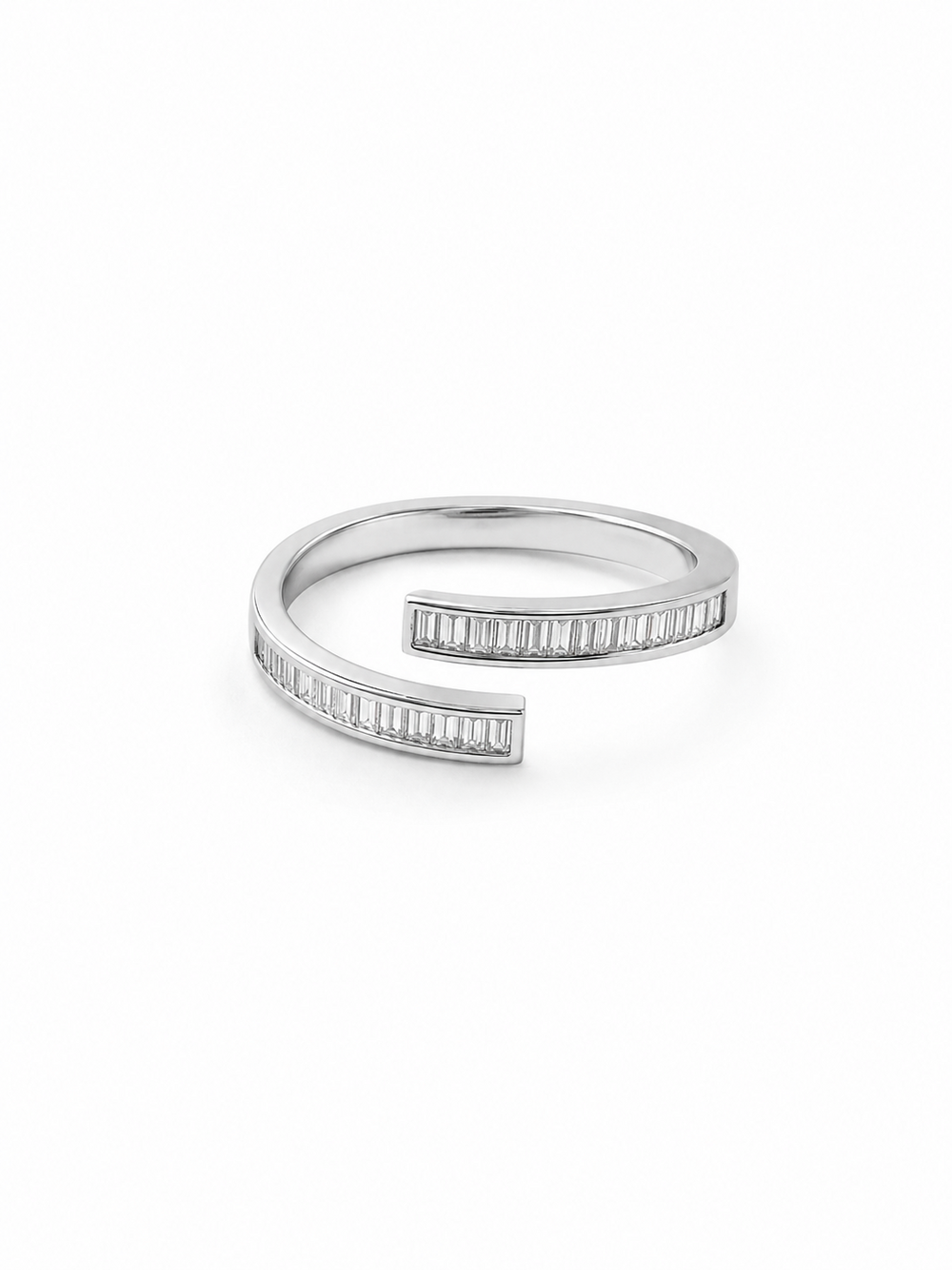 Adjustable white-gold wrap ring with two offset open ends, each channel-set with a straight row of clear baguette-cut stones, photographed at a three-quarter angle on a pure white background.
