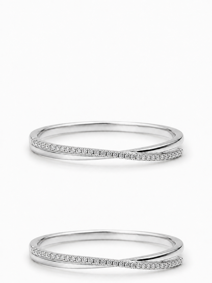 Horizontal white gold asymmetric crossover ring with a slim pavé arm and polished tapered arm