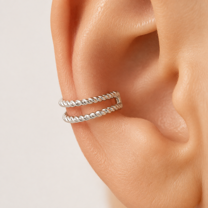 White gold double rope ear cuff worn on ear, close-up