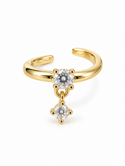 Yellow gold-tone open ear cuff with one fixed clear round stone and a smaller articulated round stone drop