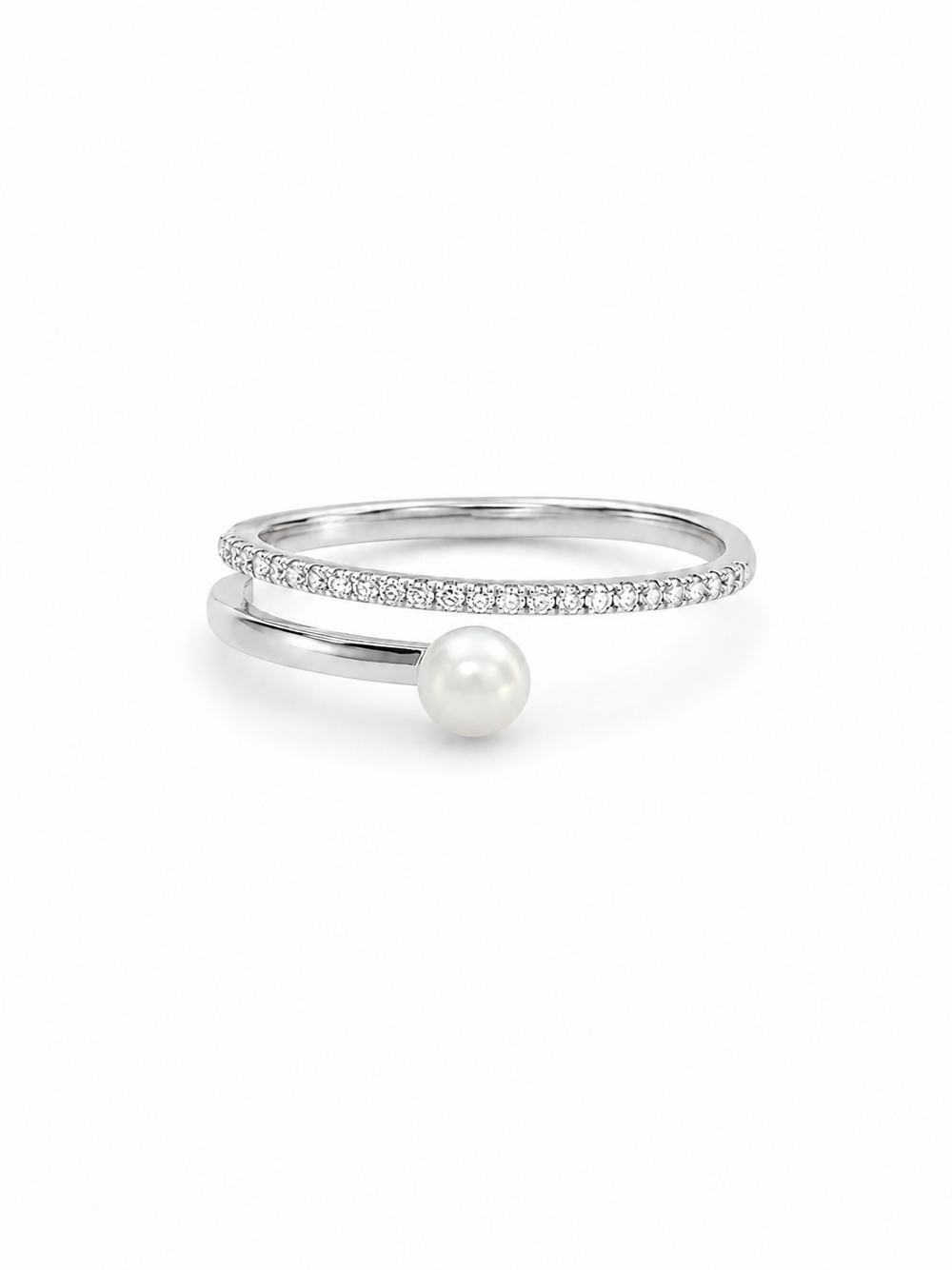 Freshwater pearl crossover ring in white gold with one slim clear pavé arc and one smooth pearl-tipped arc on a white background.