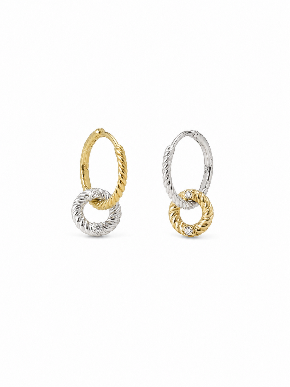 Mismatched pair of two-tone interlocking loop earrings, with one yellow-gold twisted huggie and white-gold drop loop and one white-gold huggie with yellow-gold drop loop, on white.