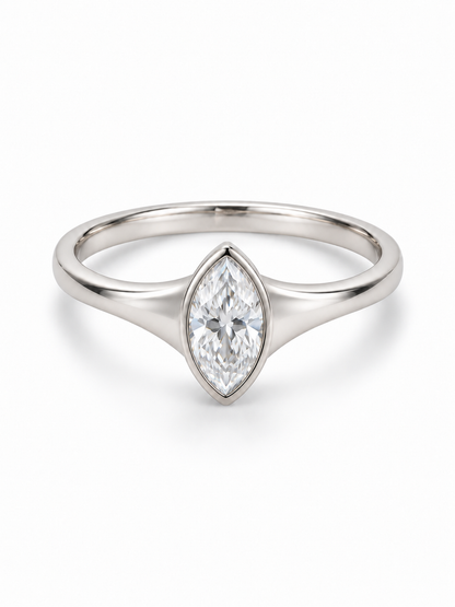 White gold ring with solid tapered shoulders and a bezel-set marquise moissanite
