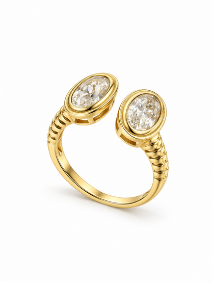 Side view of an open yellow gold-tone ring showing two oval moissanite bezel settings, ribbed shoulders, and an adjustable band