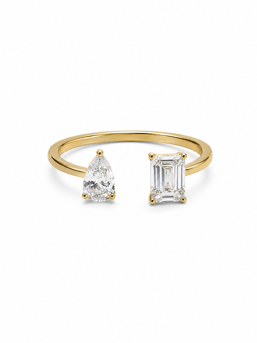 Yellow gold adjustable bypass ring with a clear pear-cut stone and emerald-cut stone on a white background.