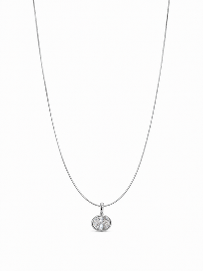 Petite single-stone white-gold bezel pendant on a fine 0.65 mm side snake chain, photographed on white.