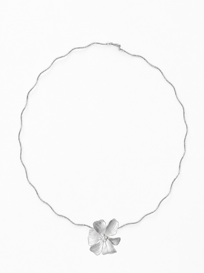 Full ecommerce product view of the Reine Clayful necklace in 18K white gold vermeil, featuring the handmade matte sculptural peony pendant with white cubic zirconia accents on The Link's flexible wavy chain against a pure white background.