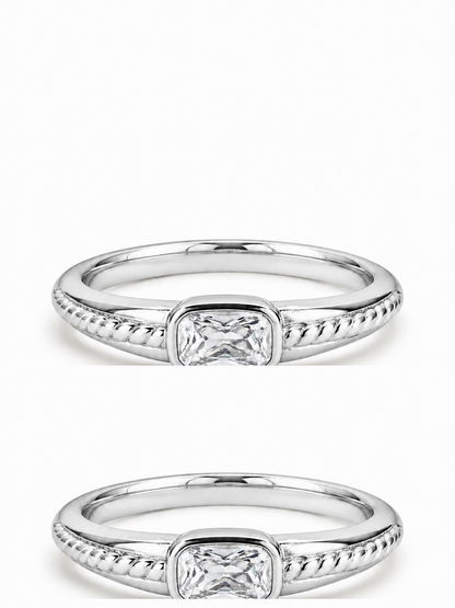 White gold east-west clear rectangular bezel ring with rope-textured shoulders