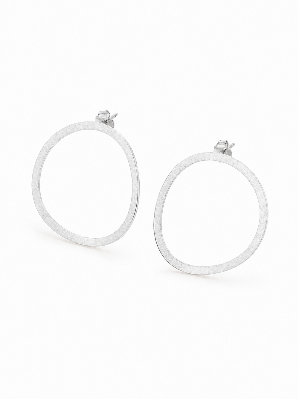 Ecommerce product view of the Seen, Not Felt statement stud earrings in 18K white gold vermeil, showing their lightweight softly irregular open outlines, fine brushed finish, slender flat construction, posts, and butterfly backs on a pure white background.