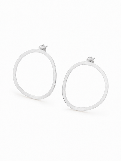 Ecommerce product view of the Seen, Not Felt statement stud earrings in 18K white gold vermeil, showing their lightweight softly irregular open outlines, fine brushed finish, slender flat construction, posts, and butterfly backs on a pure white background.