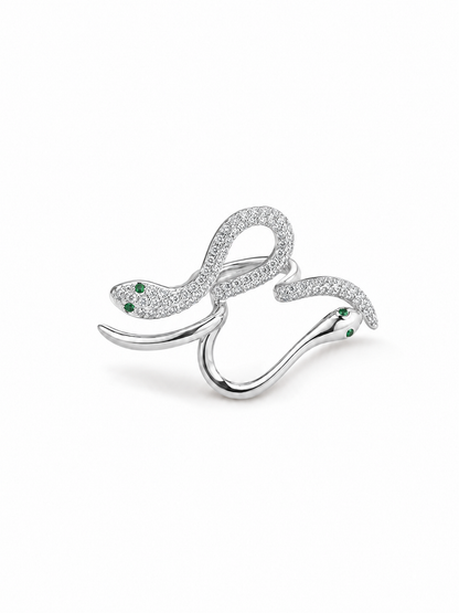 Adjustable double-serpent wrap ring in white gold with one clear pavé serpent, one polished serpent and small green eye details on white.