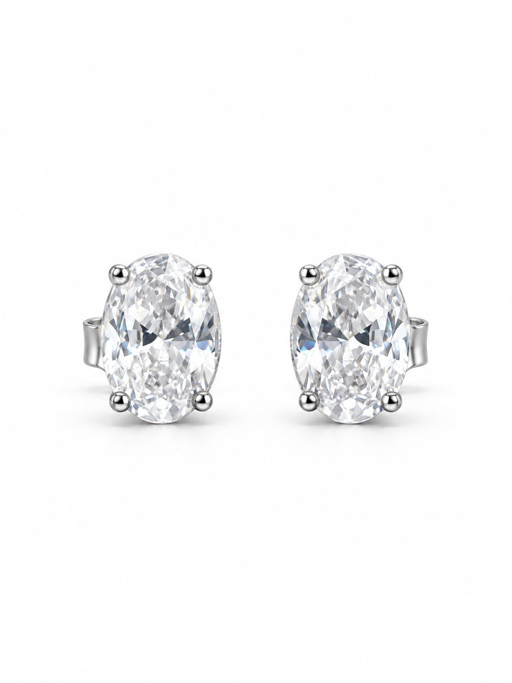 Pair of clear oval four-prong stud earrings in polished white-gold color on a white background