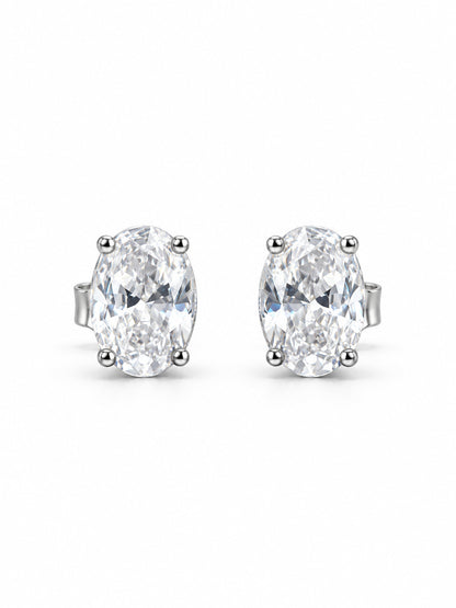 Pair of clear oval four-prong stud earrings in polished white-gold color on a white background