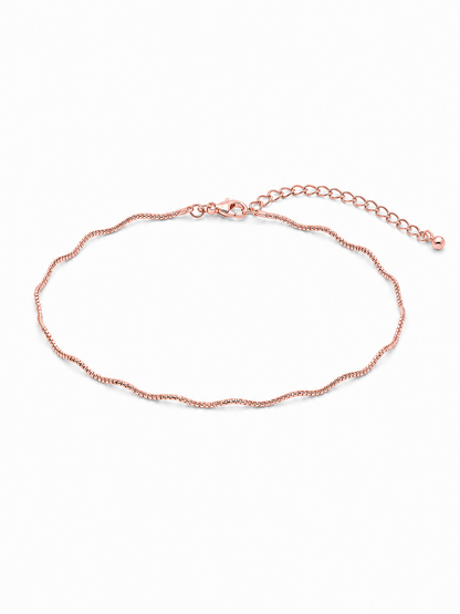 Solene wavy bracelet in rose gold, styled in a small horizontal wrist-sized oval with its undulating chain profile and 2-inch adjustable extension fully visible on white.
