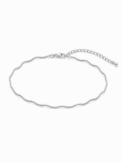 Solene wavy bracelet in white gold, showing its fine reflective sculptural chain, compact wrist proportions, lobster clasp and 2-inch extension on a white background.