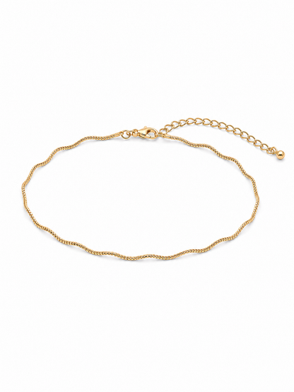 Solene wavy bracelet in yellow gold, arranged as a compact wrist-sized oval with its lobster clasp and full 2-inch extension chain visible on a white background.