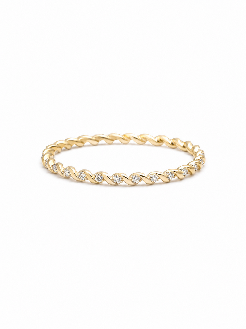 Slim twisted pavé band ring in yellow gold with repeating polished diagonal folds and tiny clear stone accents on a white background.