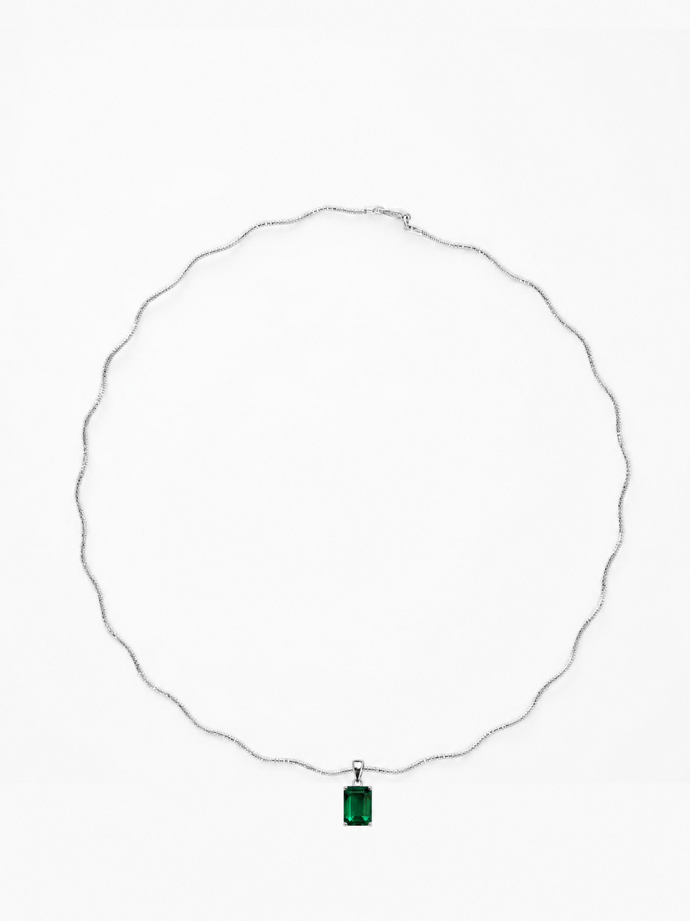 Verda emerald-green rectangular pendant on a white-gold sculptural necklace, shown on white.