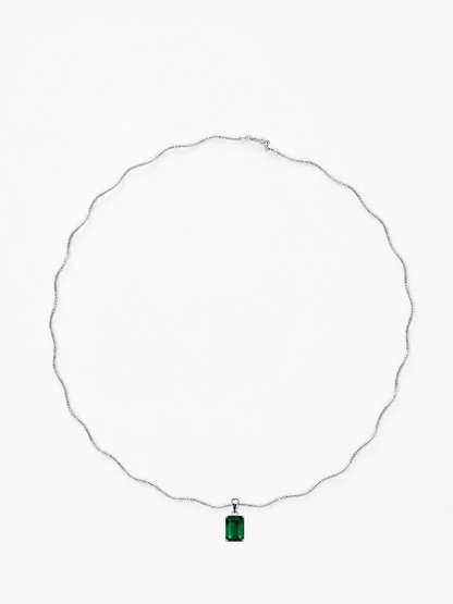 Verda emerald-green rectangular pendant on a white-gold sculptural necklace, shown on white.